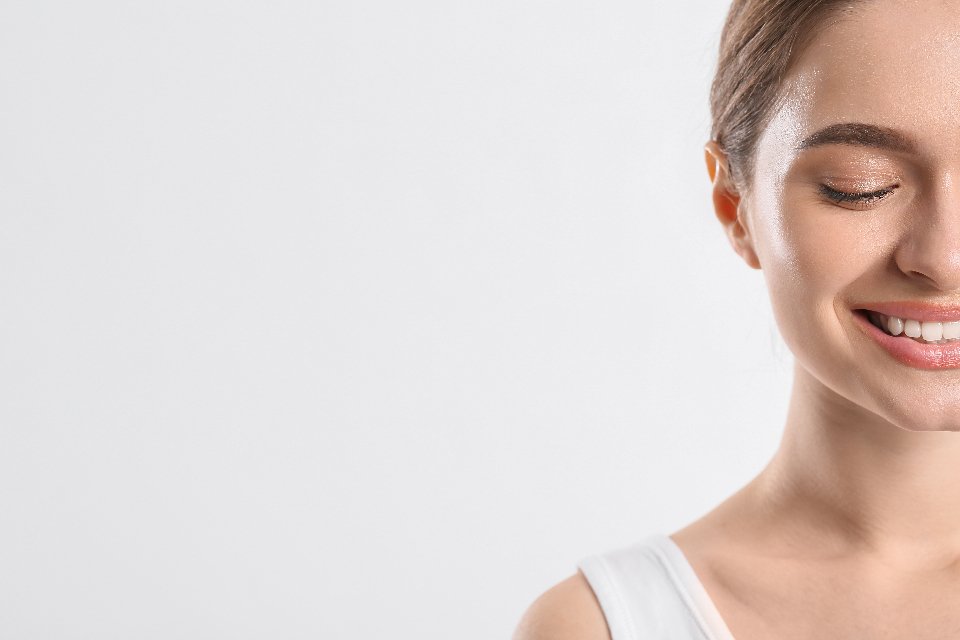 A woman smiling with no visible orthodontic appliance