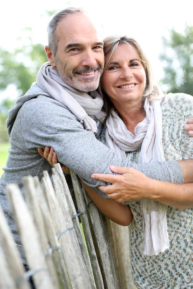 A mature couple smiling together outdoors