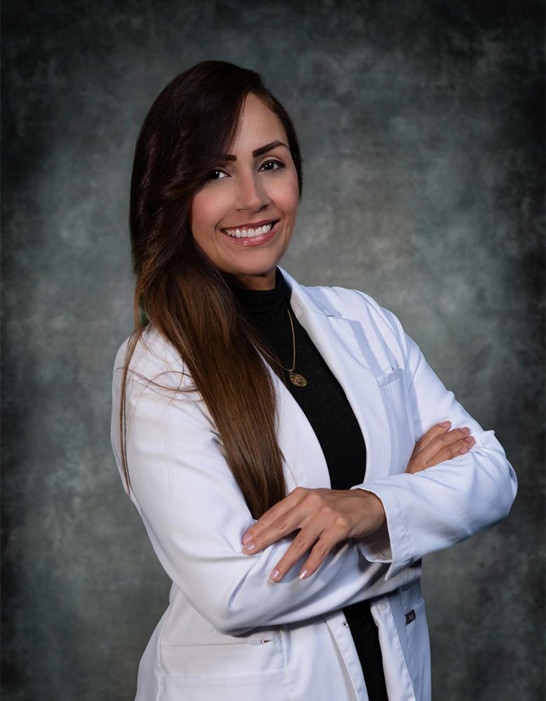 Dr. Gabriela A. Romero, DDS, in her white coat
