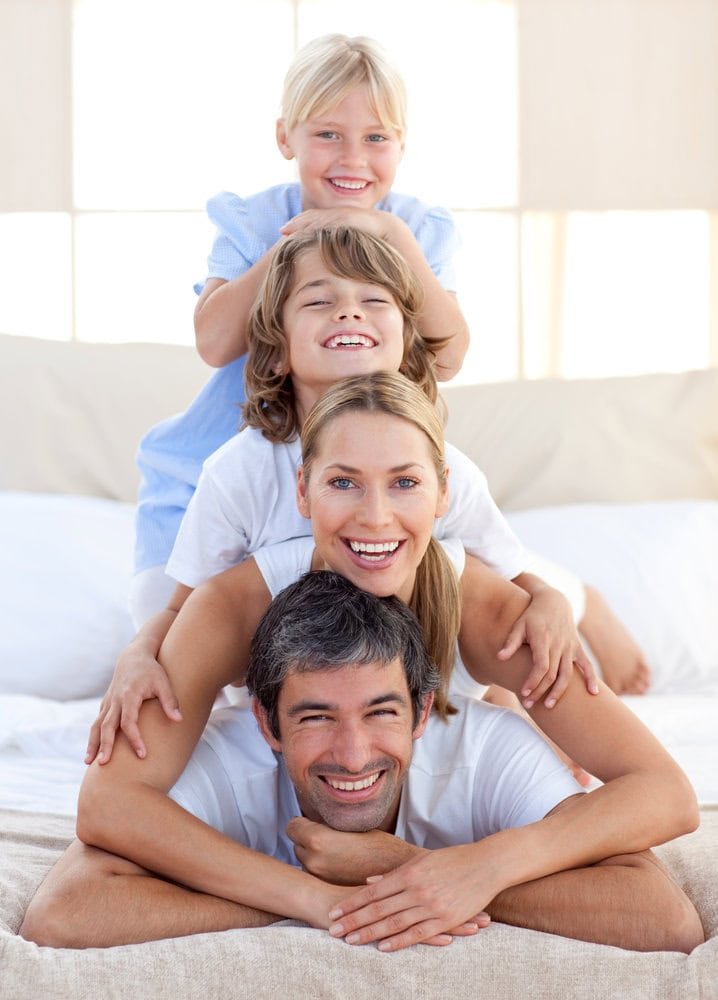 Two parents and their two children smiling together