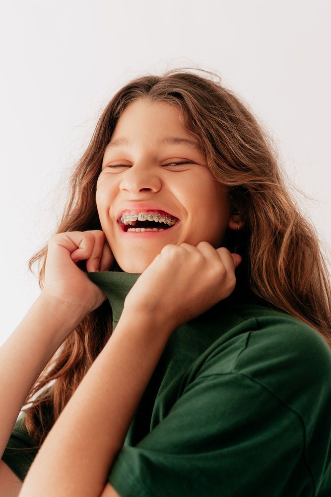 A young woman laughing, wearing orthodontic braces