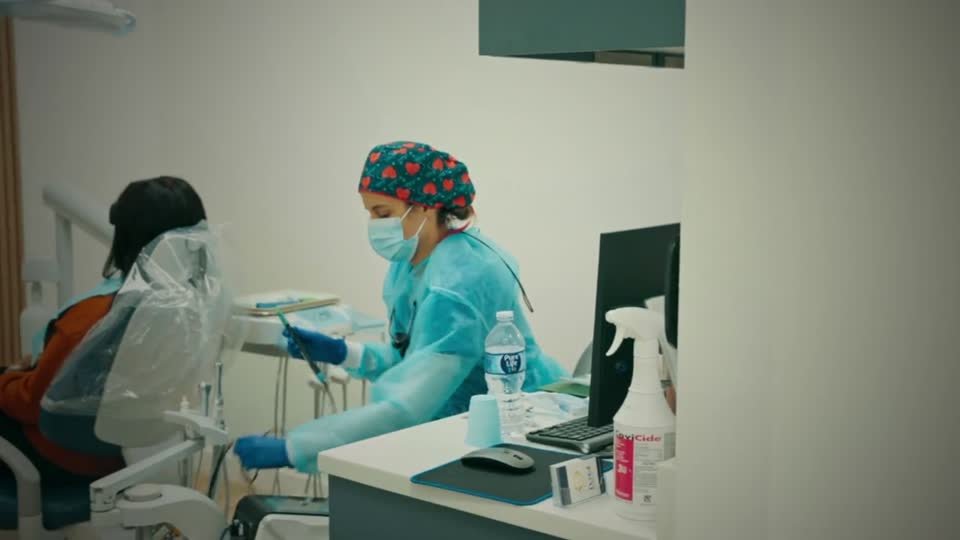 One of our clinicians preparing instruments beside a patient in the chair, in a treatment room at our St. Cloud office
